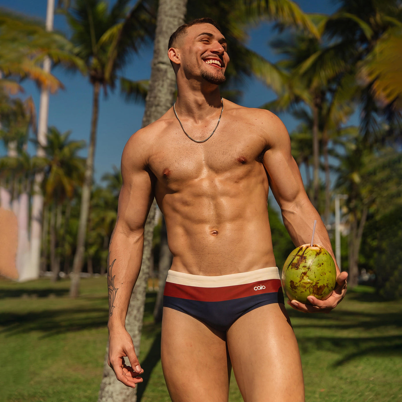 Caio Arpoador tricolor swim brief on the beach in Rio
