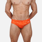 Model wearing Slim Caio Brazilian swim brief in Solar Flare (orange)