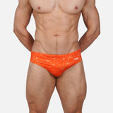 Model wearing Slim Caio Brazilian swim brief in Solar Flare (orange)