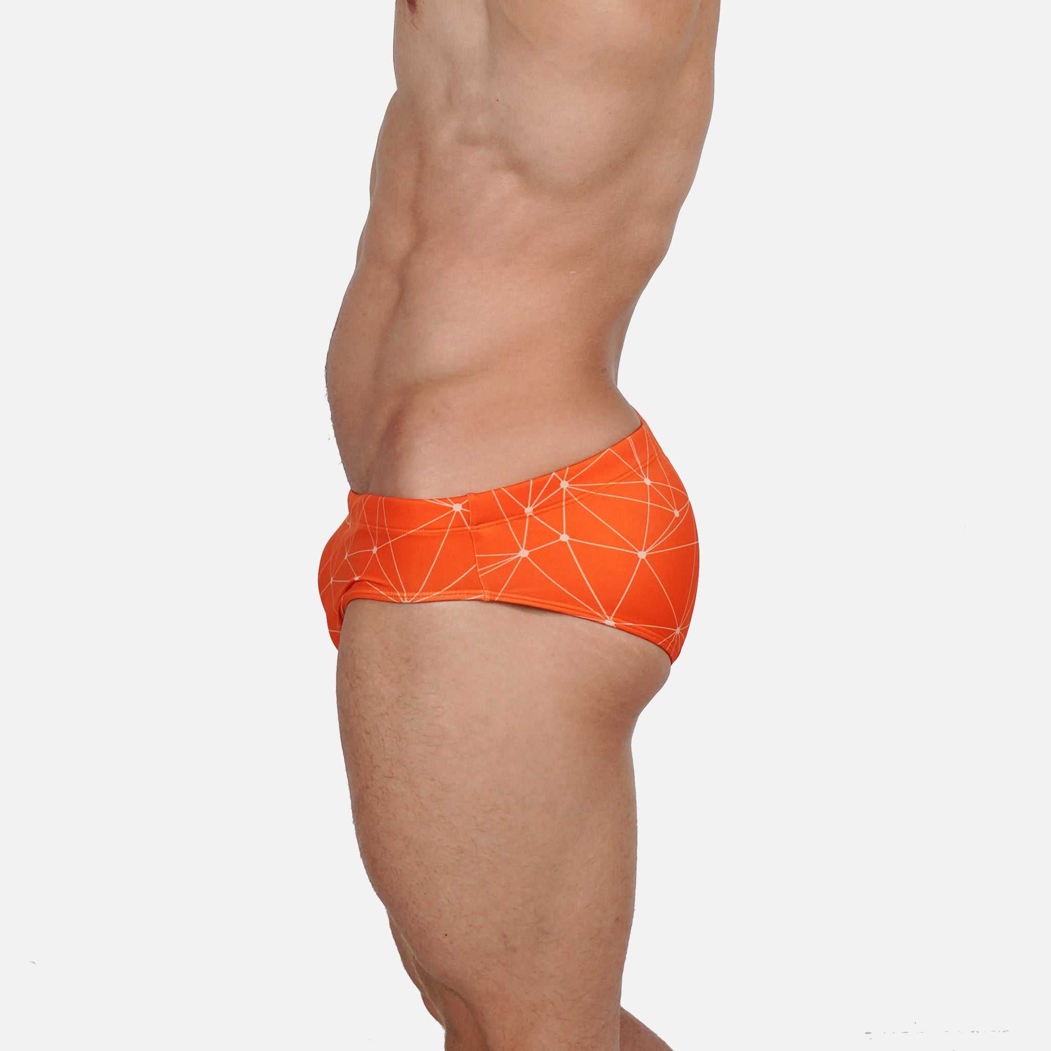 Model wearing Slim Caio Brazilian swim brief in Solar Flare (orange)