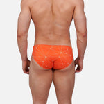 Model wearing Slim Caio Brazilian swim brief in Solar Flare (orange)