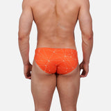 Model wearing Slim Caio Brazilian swim brief in Solar Flare (orange)