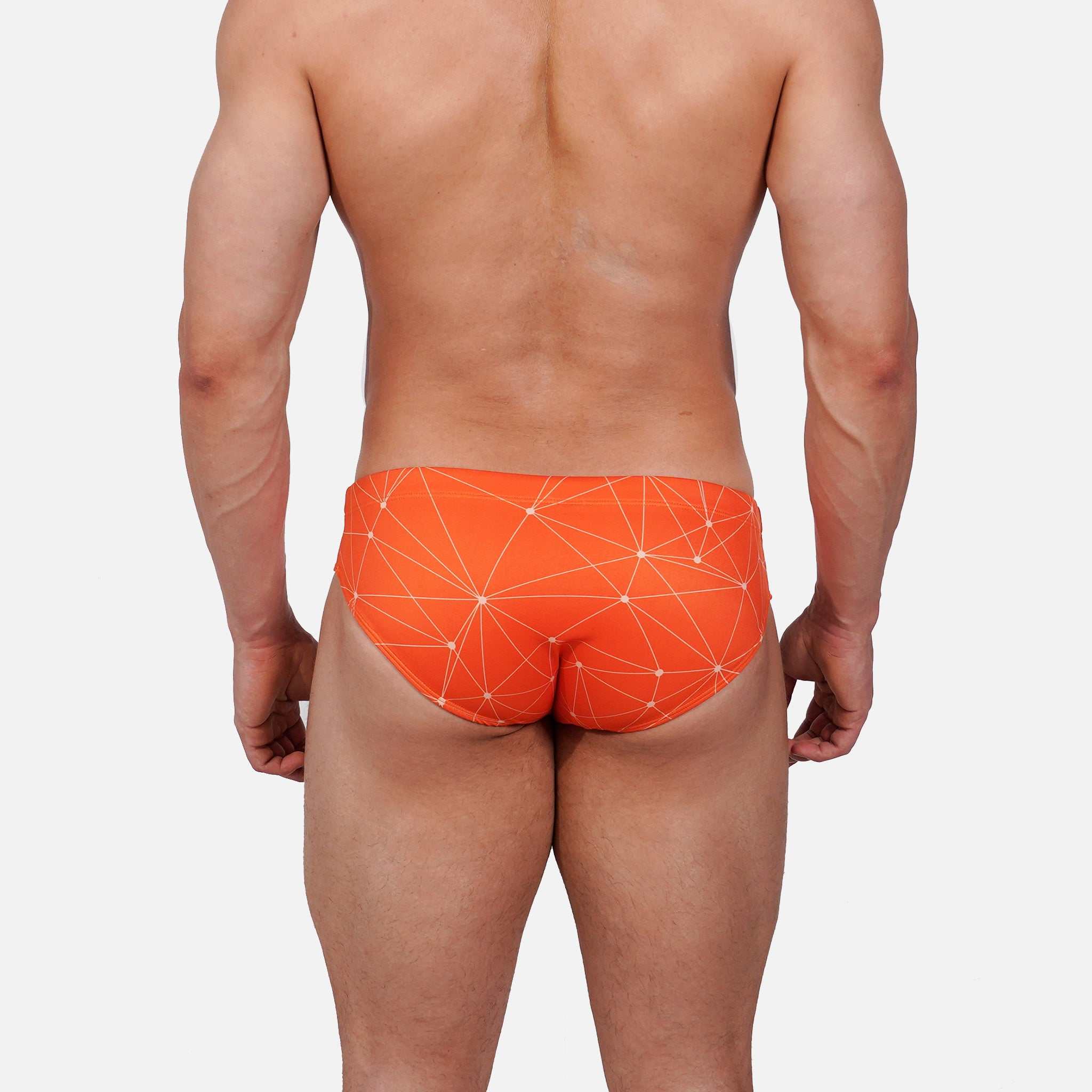 Model wearing Slim Caio Brazilian swim brief in Solar Flare (orange)