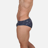 Model wearing Slim Caio Brazilian swim brief in Stellar Ash (dark gray)