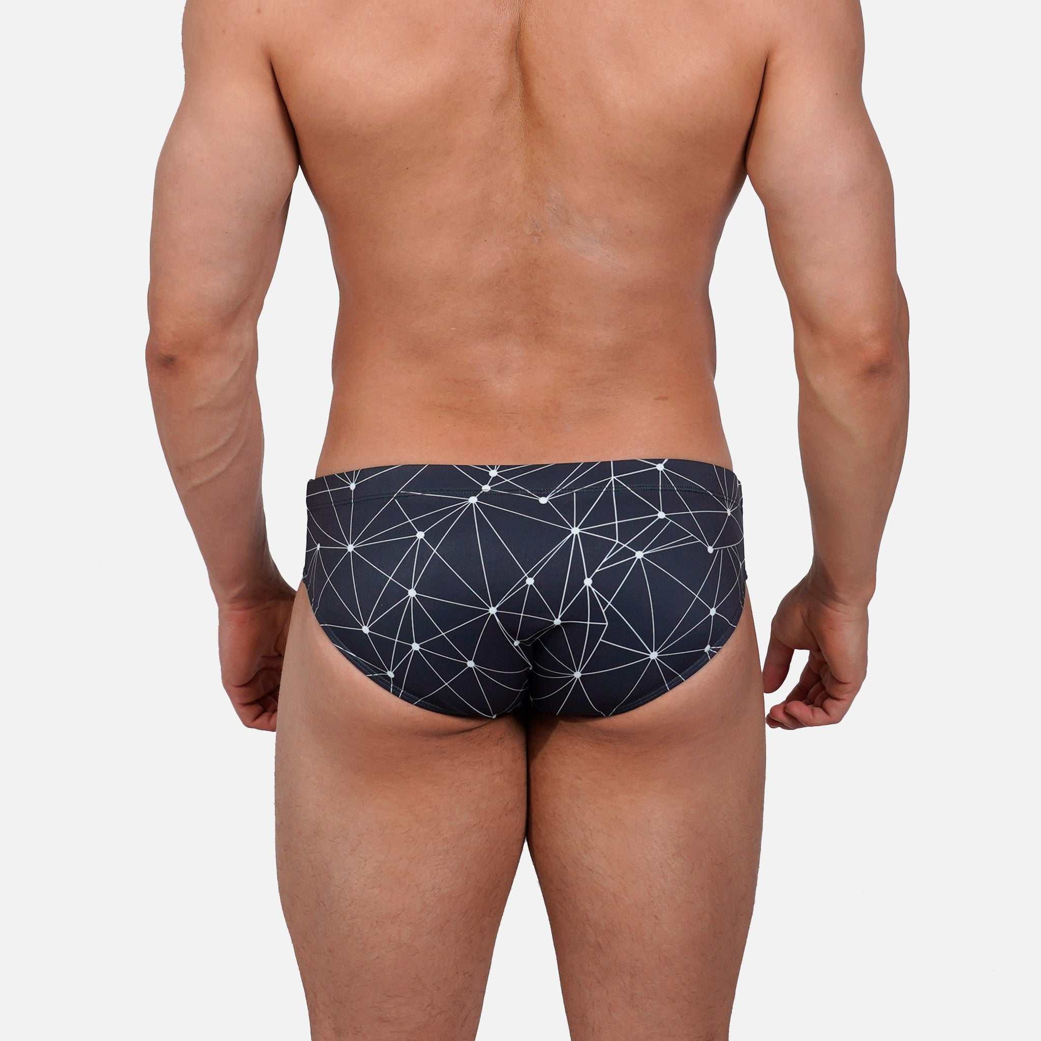 Model wearing Slim Caio Brazilian swim brief in Stellar Ash (dark gray)