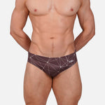 Model wearing Slim Caio Brazilian swim brief in Astral Soil (brown)