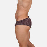 Model wearing Slim Caio Brazilian swim brief in Astral Soil (brown)