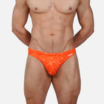 Model wearing Bikini Caio Brazilian swim brief in Solar Flare (orange)