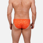 Model wearing Bikini Caio Brazilian swim brief in Solar Flare (orange)