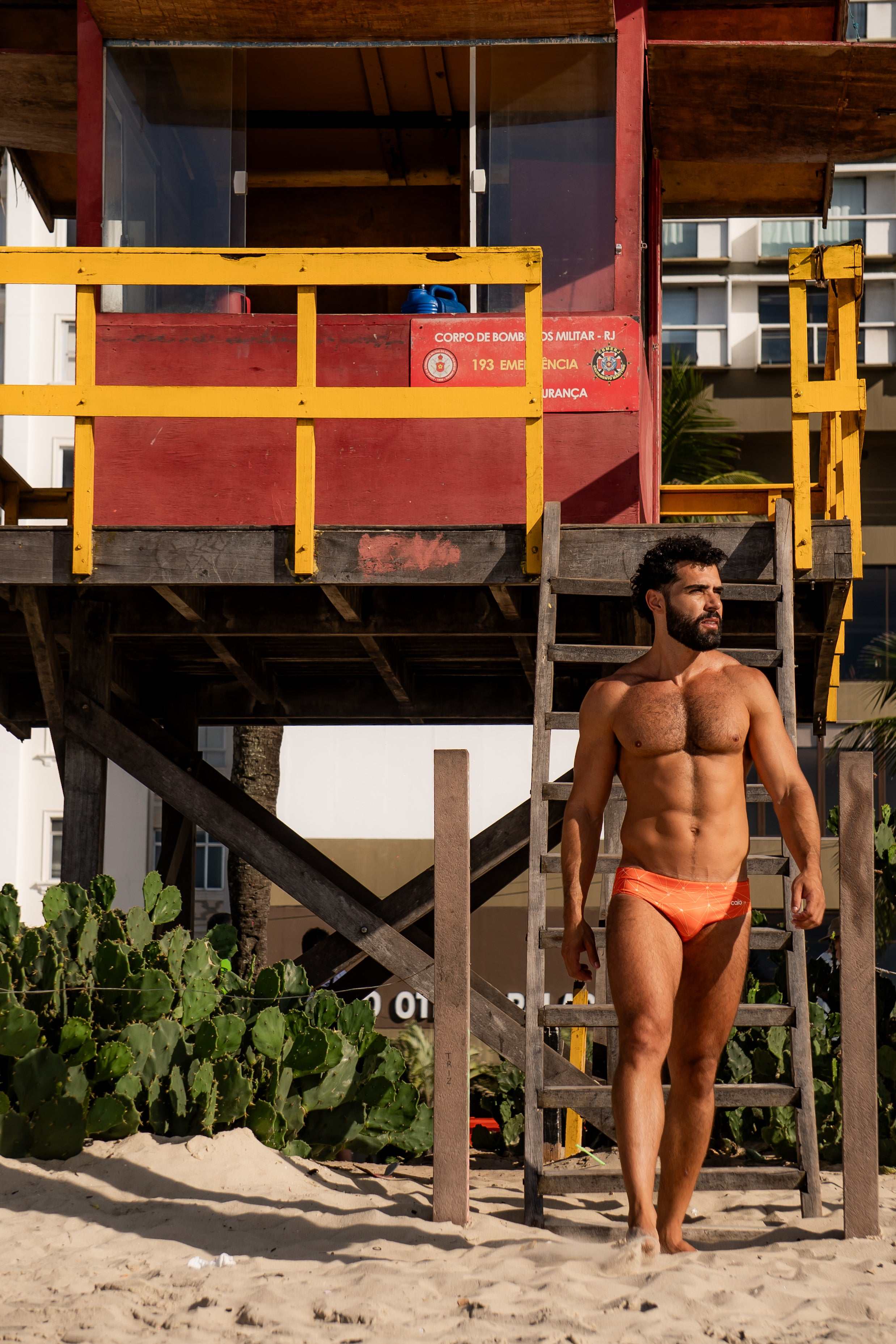 Model wearing Slim Caio Brazilian swim brief in Solar Flare (orange)