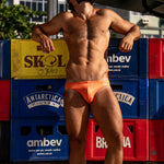 Model wearing Bikini Caio Brazilian swim brief in Solar Flare (orange)