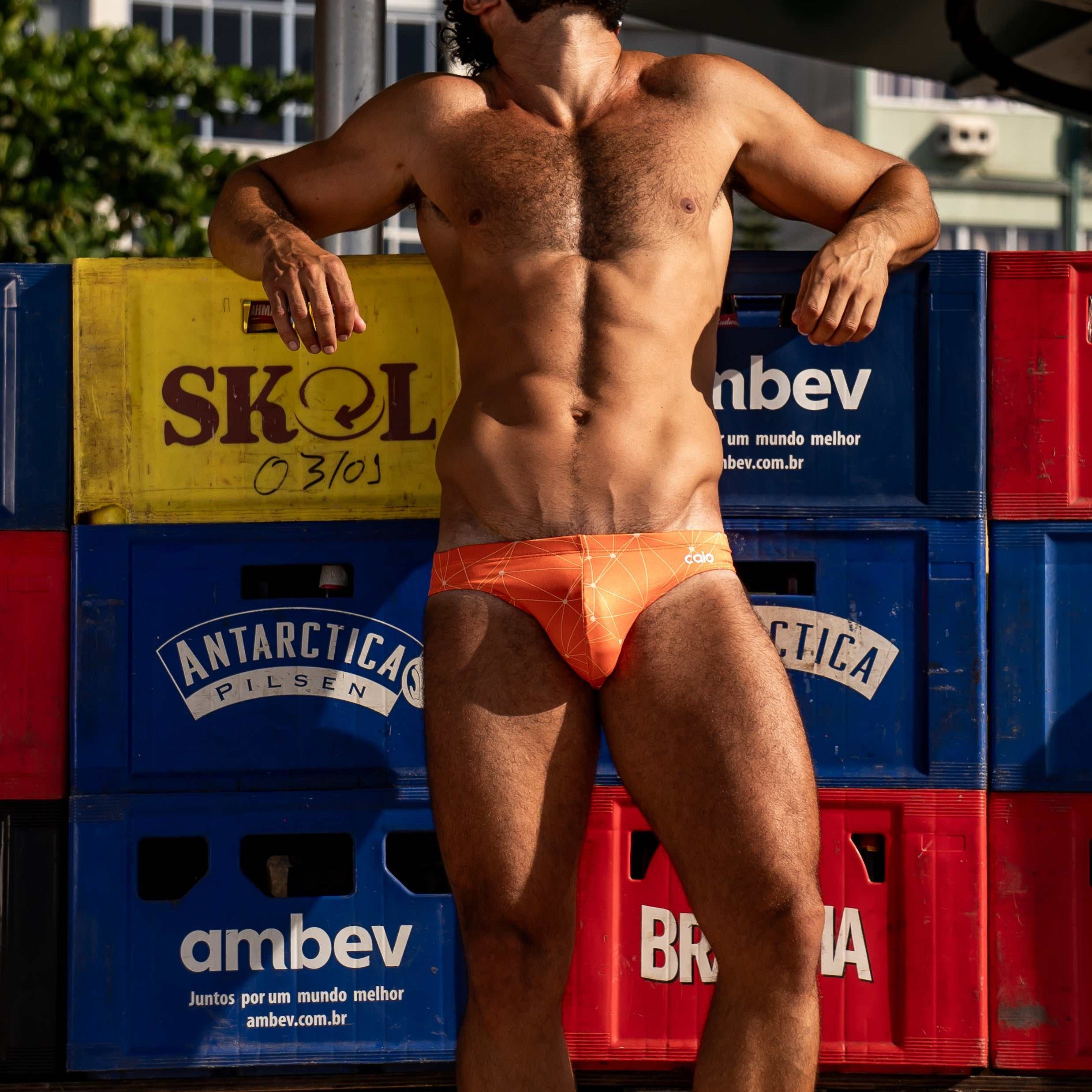 Model wearing Bikini Caio Brazilian swim brief in Solar Flare (orange)