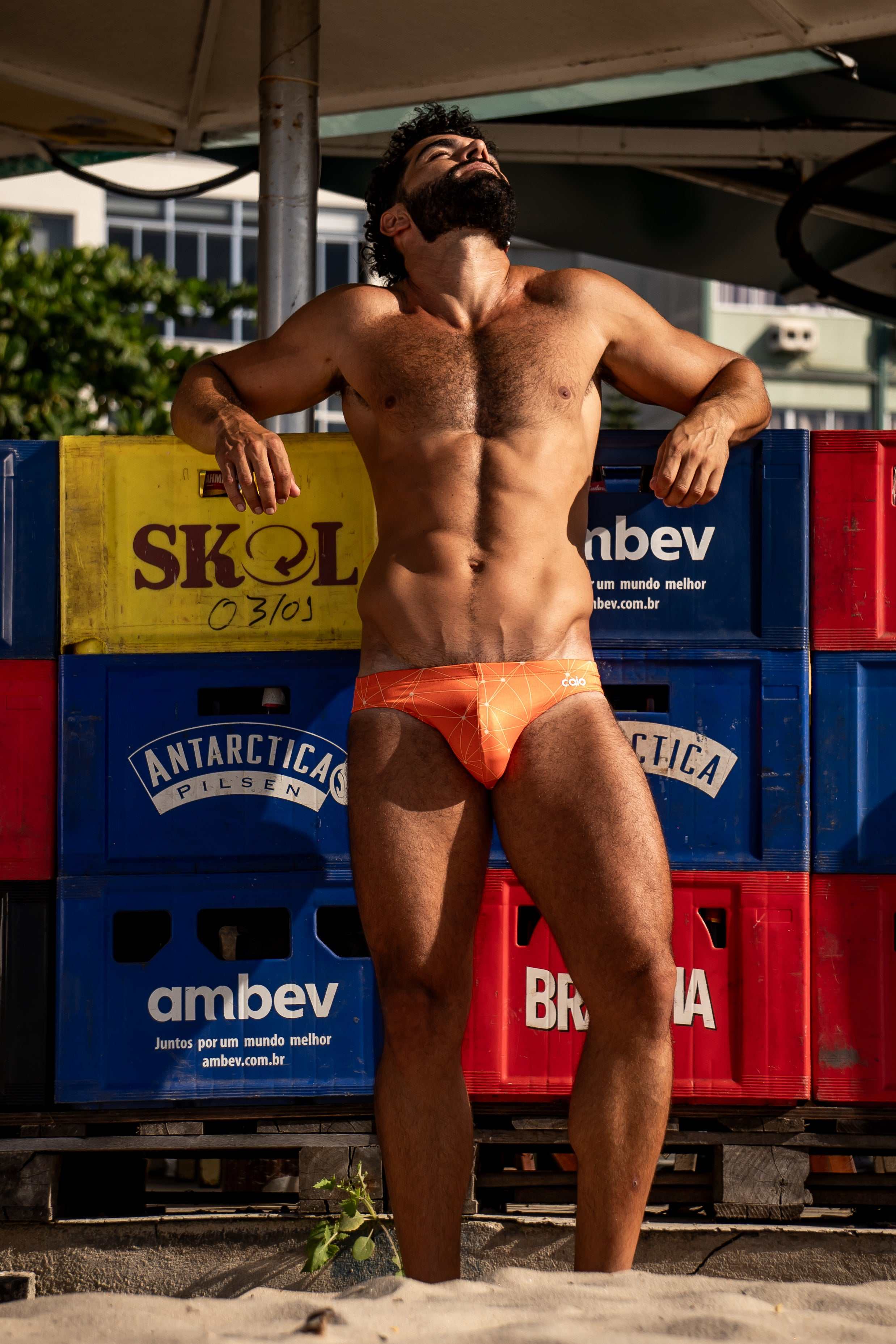 Model wearing Bikini Caio Brazilian swim brief in Solar Flare (orange)