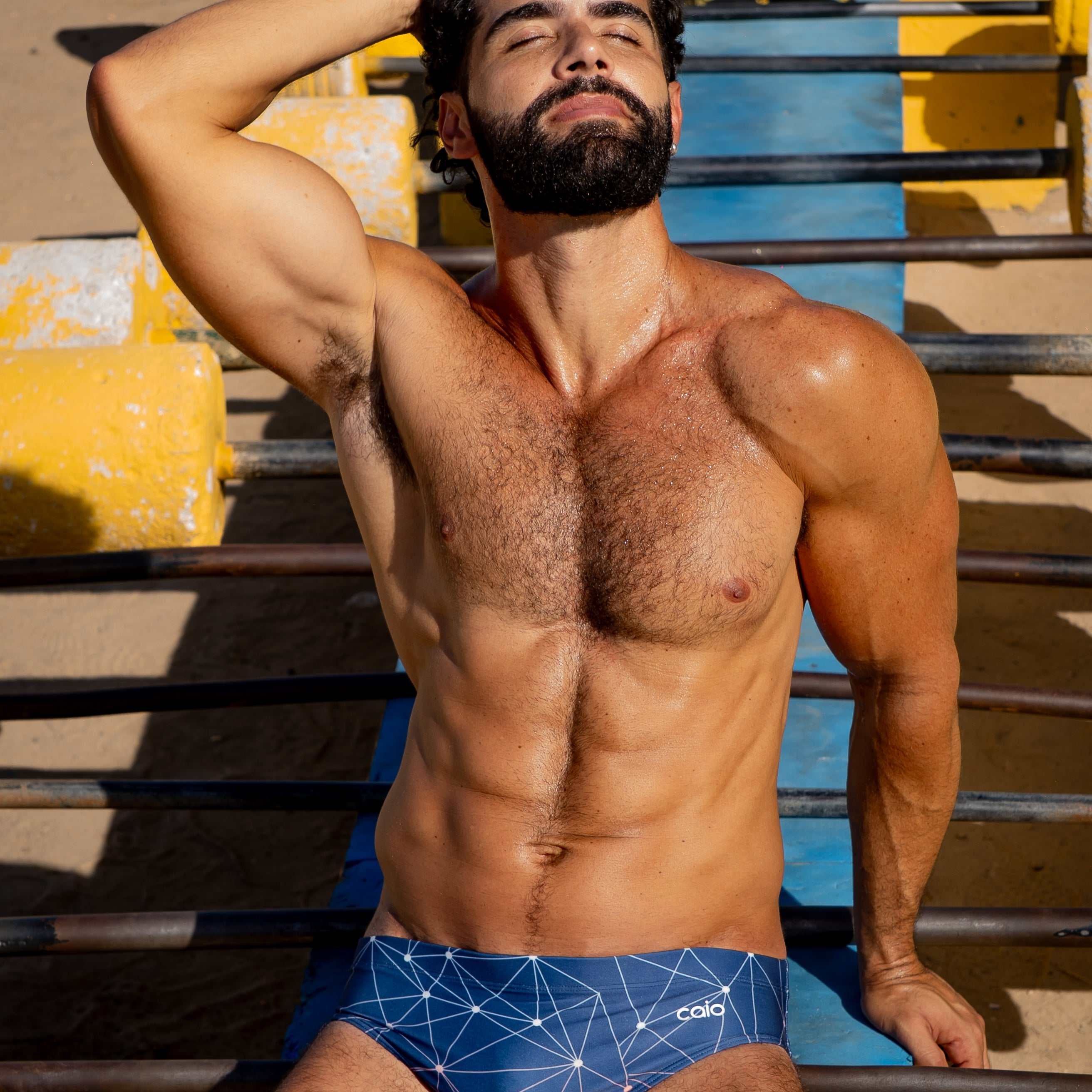 Model wearing Slim Caio Brazilian swim brief in Celestial Azure (blue)