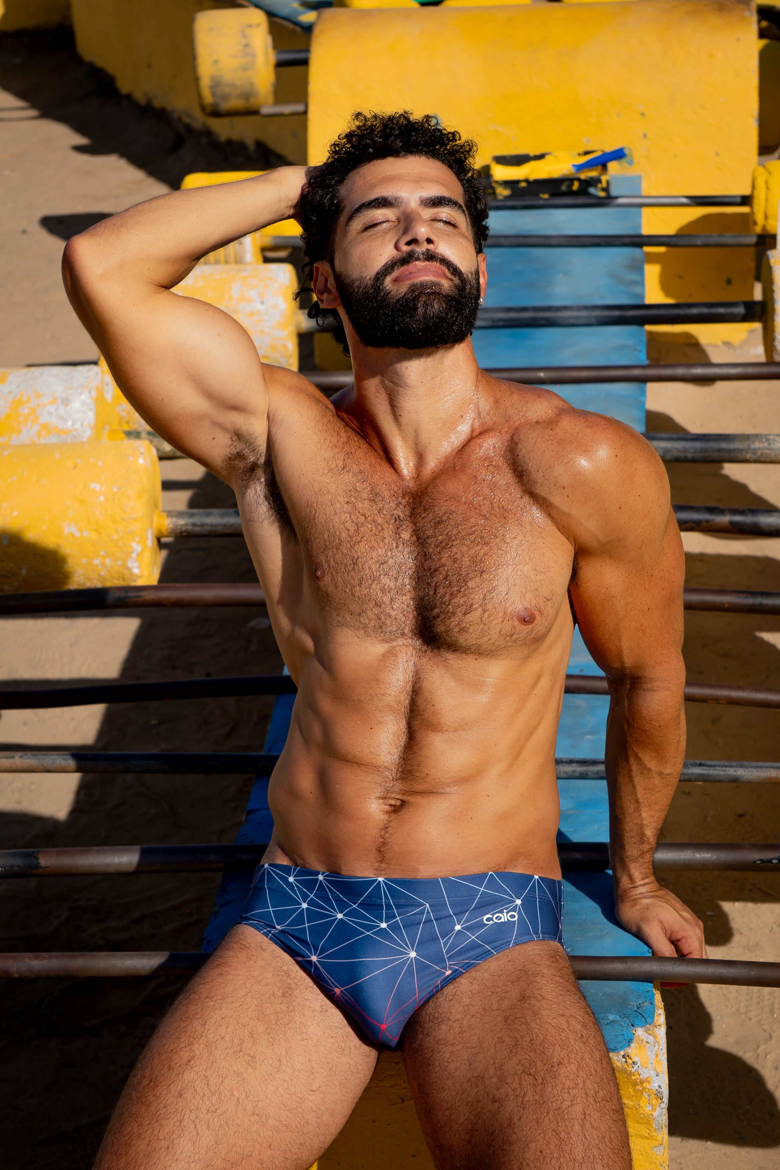 Model wearing Slim Caio Brazilian swim brief in Celestial Azure (blue)