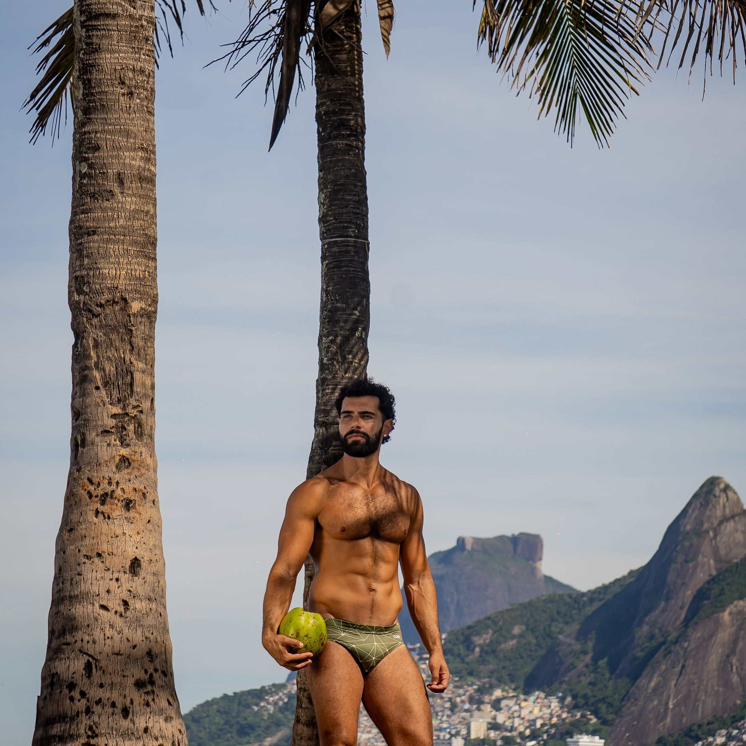 Model wearing Slim Caio Brazilian swim brief in Astro Moss (olive green)