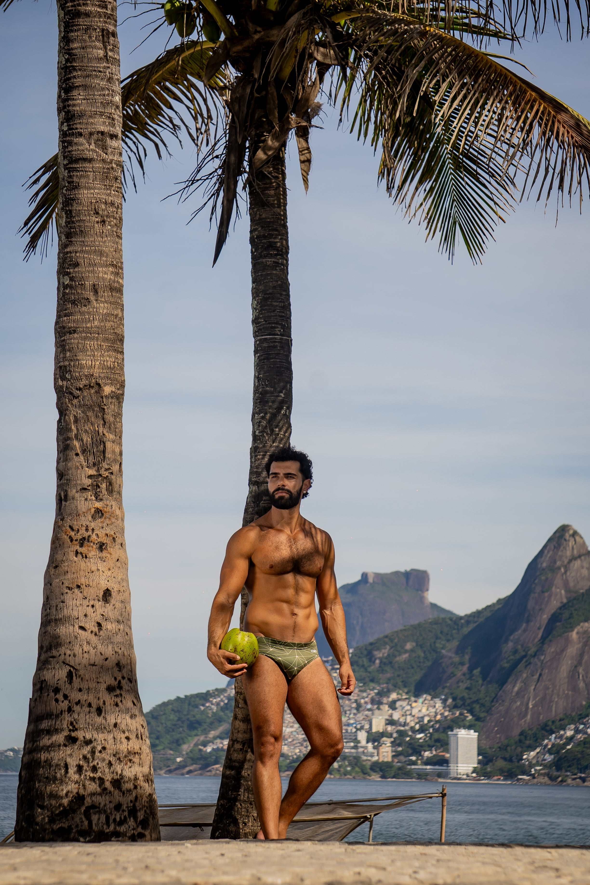 Model wearing Slim Caio Brazilian swim brief in Astro Moss (olive green)