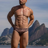 Model wearing Slim Caio Brazilian swim brief in Astral Soil (brown)