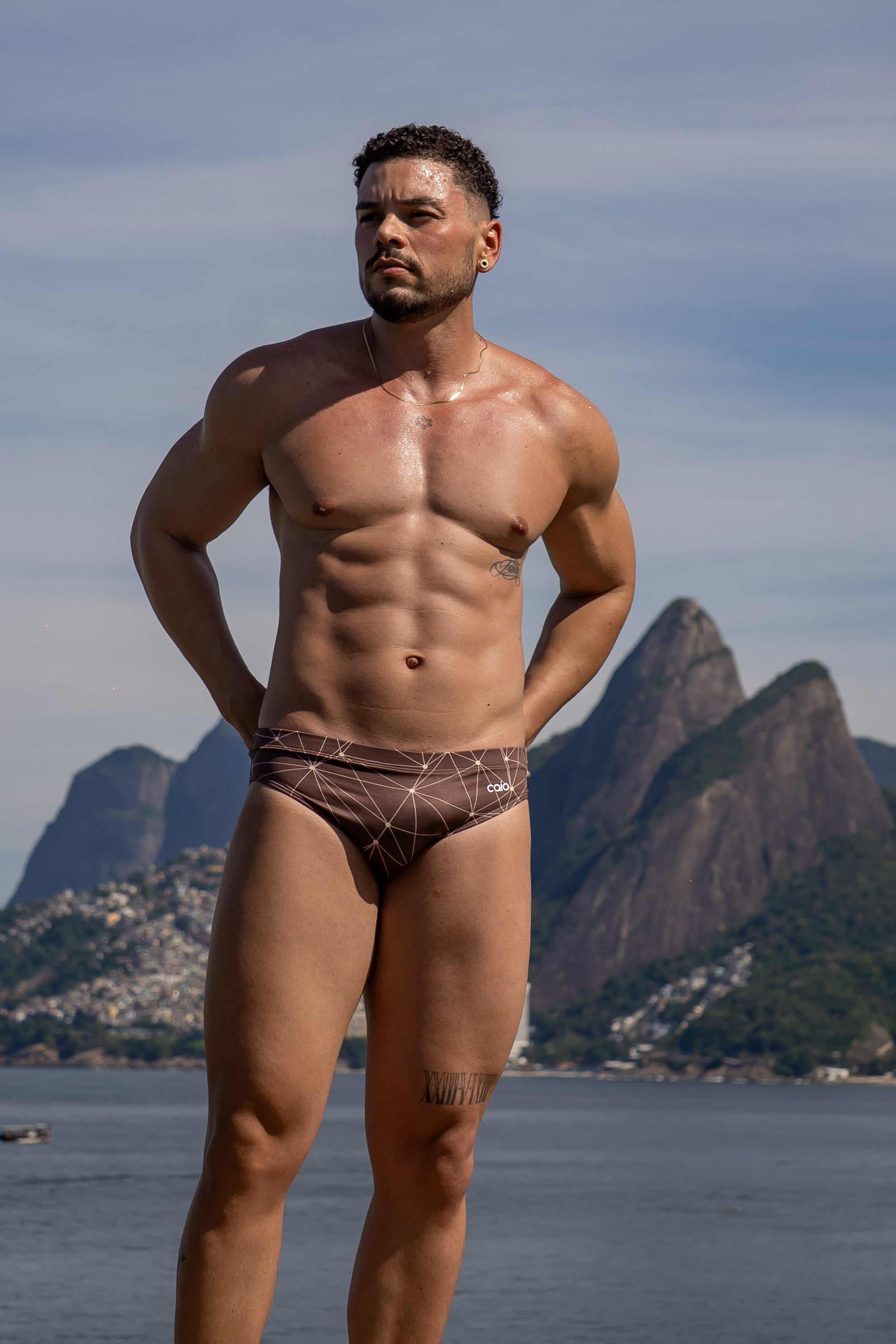 Model wearing Slim Caio Brazilian swim brief in Astral Soil (brown)