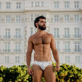 Model wearing Bikini Caio Brazilian swim brief in Nova Frost (white) outside Copacabana Palace.