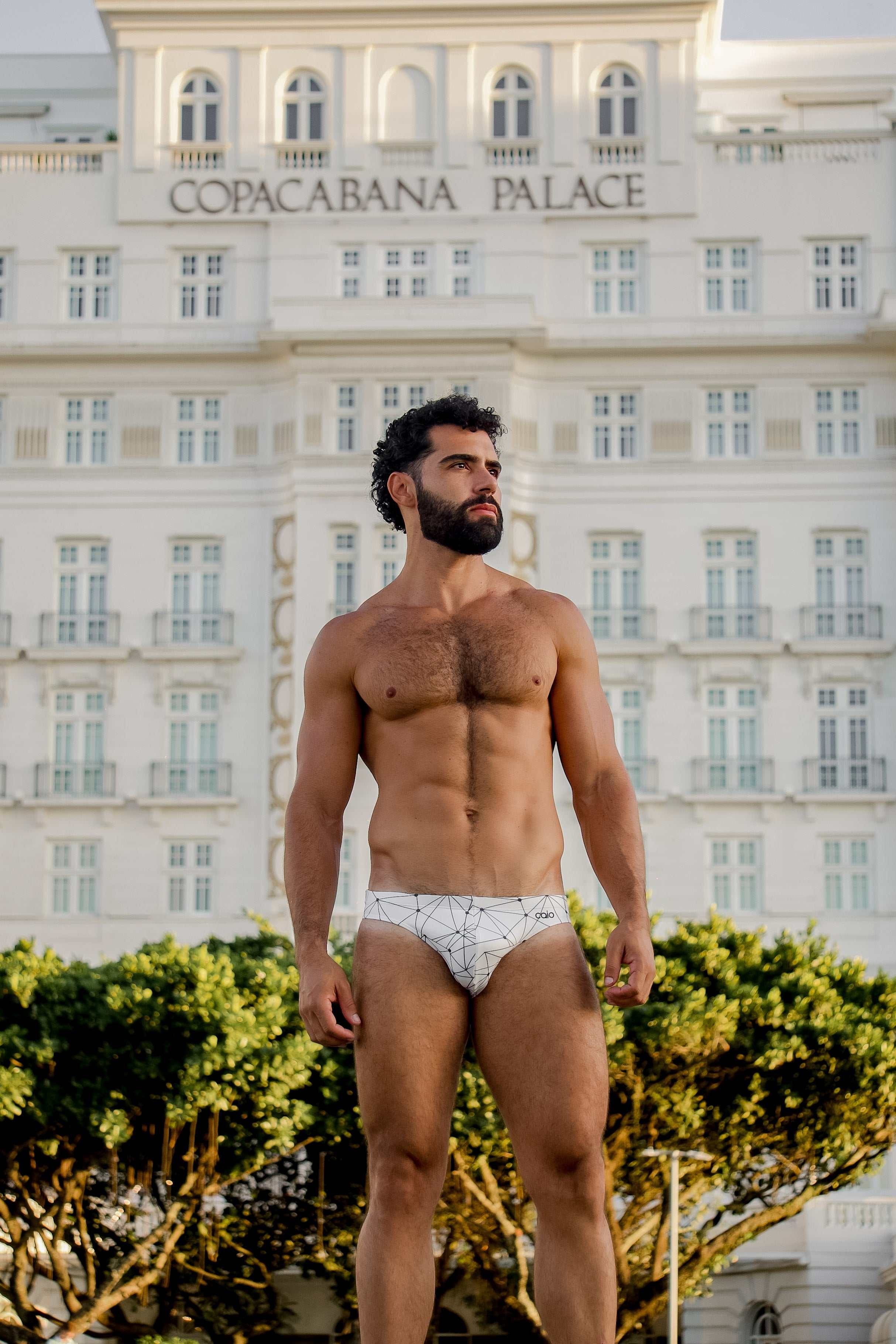 Model wearing Bikini Caio Brazilian swim brief in Nova Frost (white) outside Copacabana Palace.
