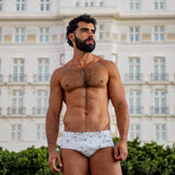 model wearing caio classic nova frost swim brief in front copacabana hotel